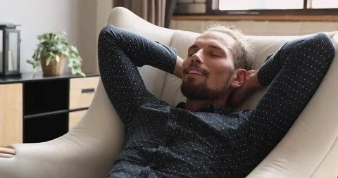 Hombre recostado con expresión de tranquilidad profunda, simbolizando relajación, liberación emocional y bienestar interior.